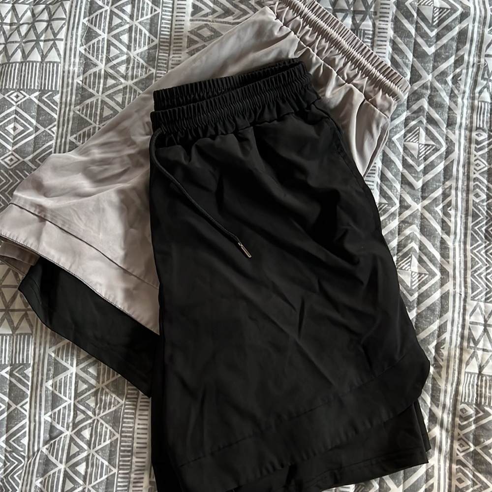 Two pair of athletic shorts with spandex attached underneath